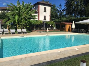 A swimming pool with lounge chairs and a building in the background. - Park Hotel Elefante (Verona)