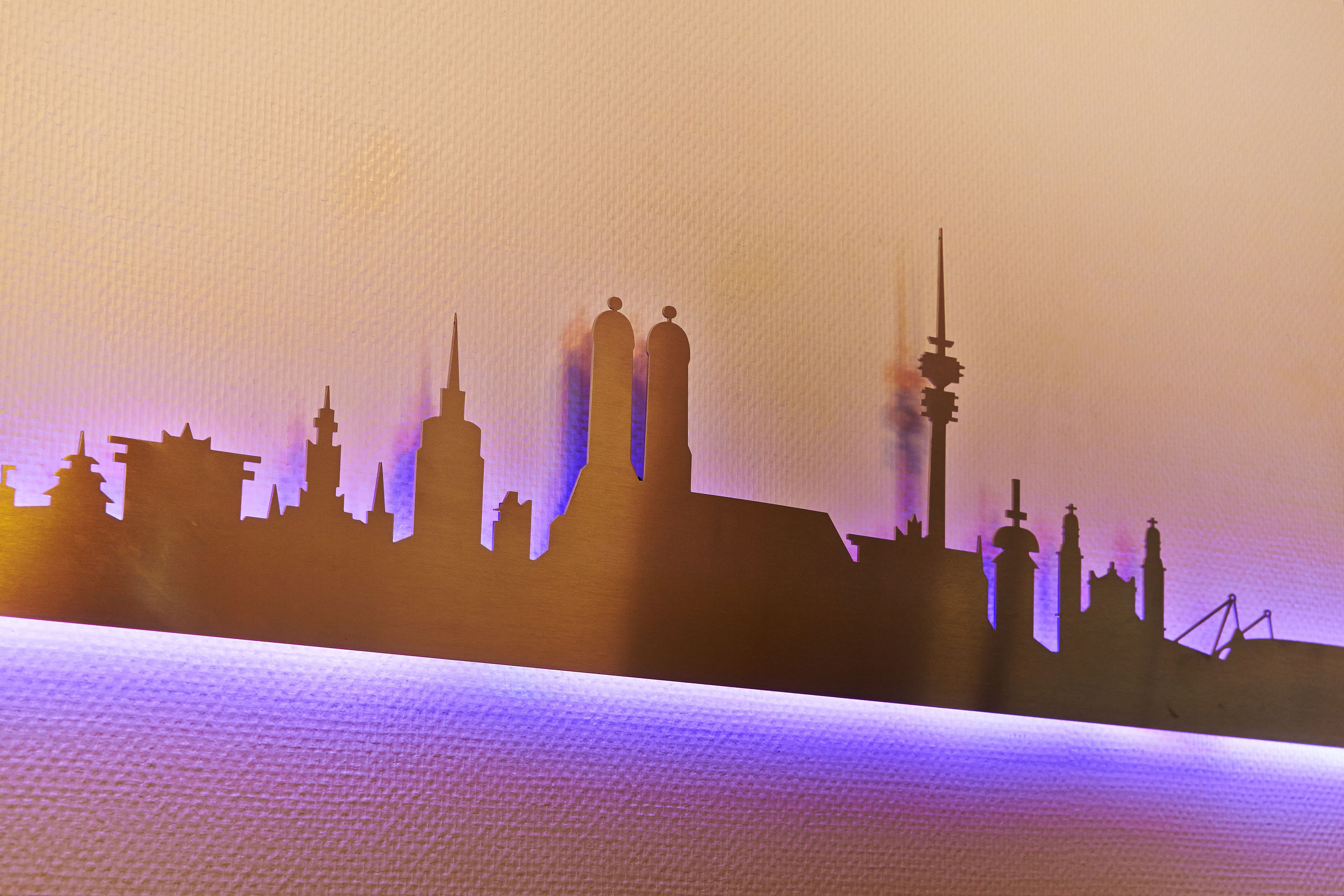A silhouette of a city skyline with prominent buildings and a bridge.