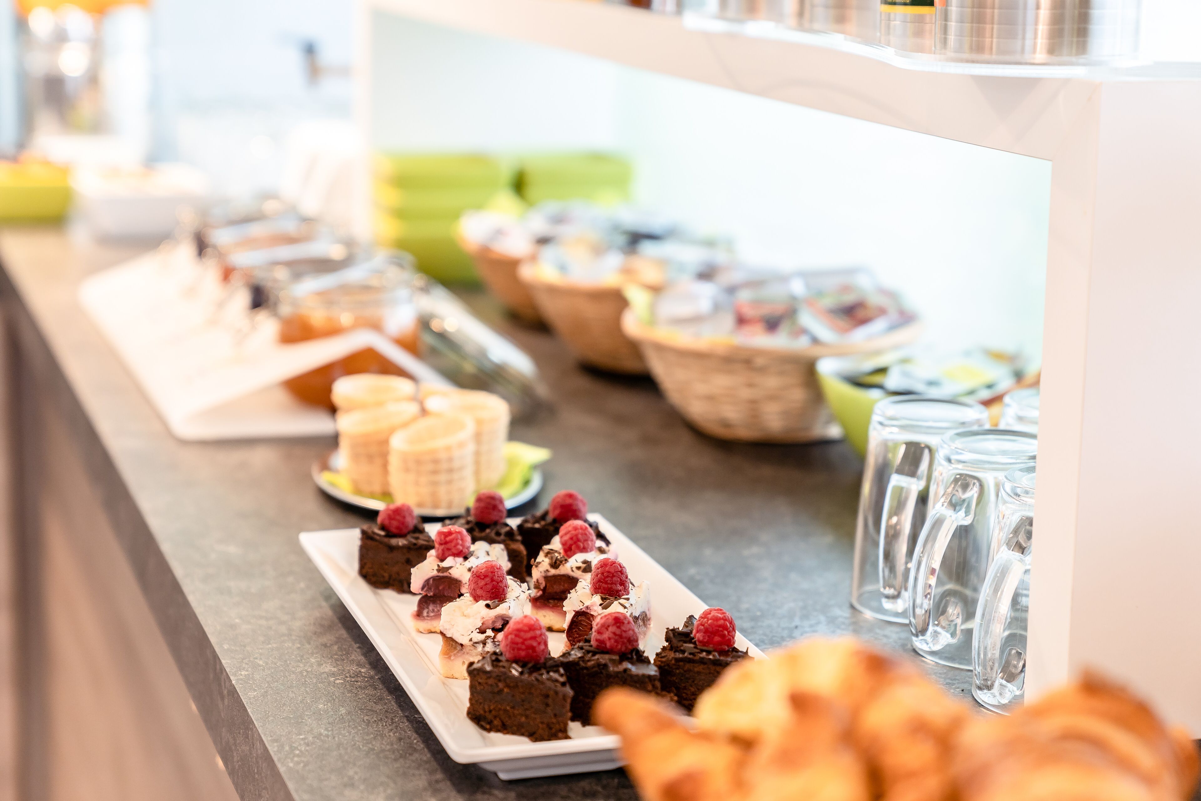 Un bufé con diversos postres y bebidas.