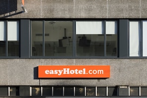 Um edifício com uma placa na fachada que diz "easyHotel.com".