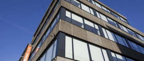 A modern building with multiple floors, large windows, and signage for easyHotel.com.