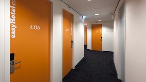 Un pasillo de hotel con puertas anaranjadas, números 4.06, 4.07 y 4.11.
