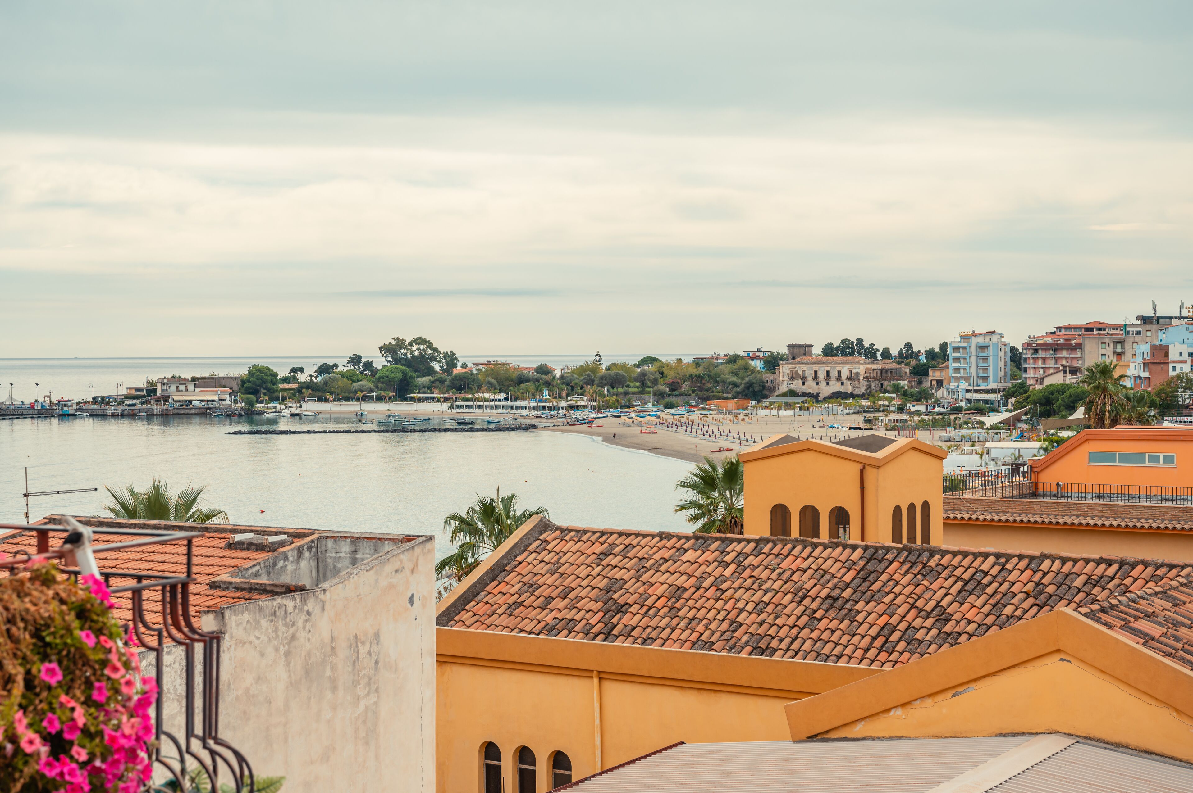 A coastal cityscape with a view of the sea, buildings, and a beach.