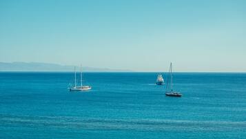 A calm sea with three sailboats.