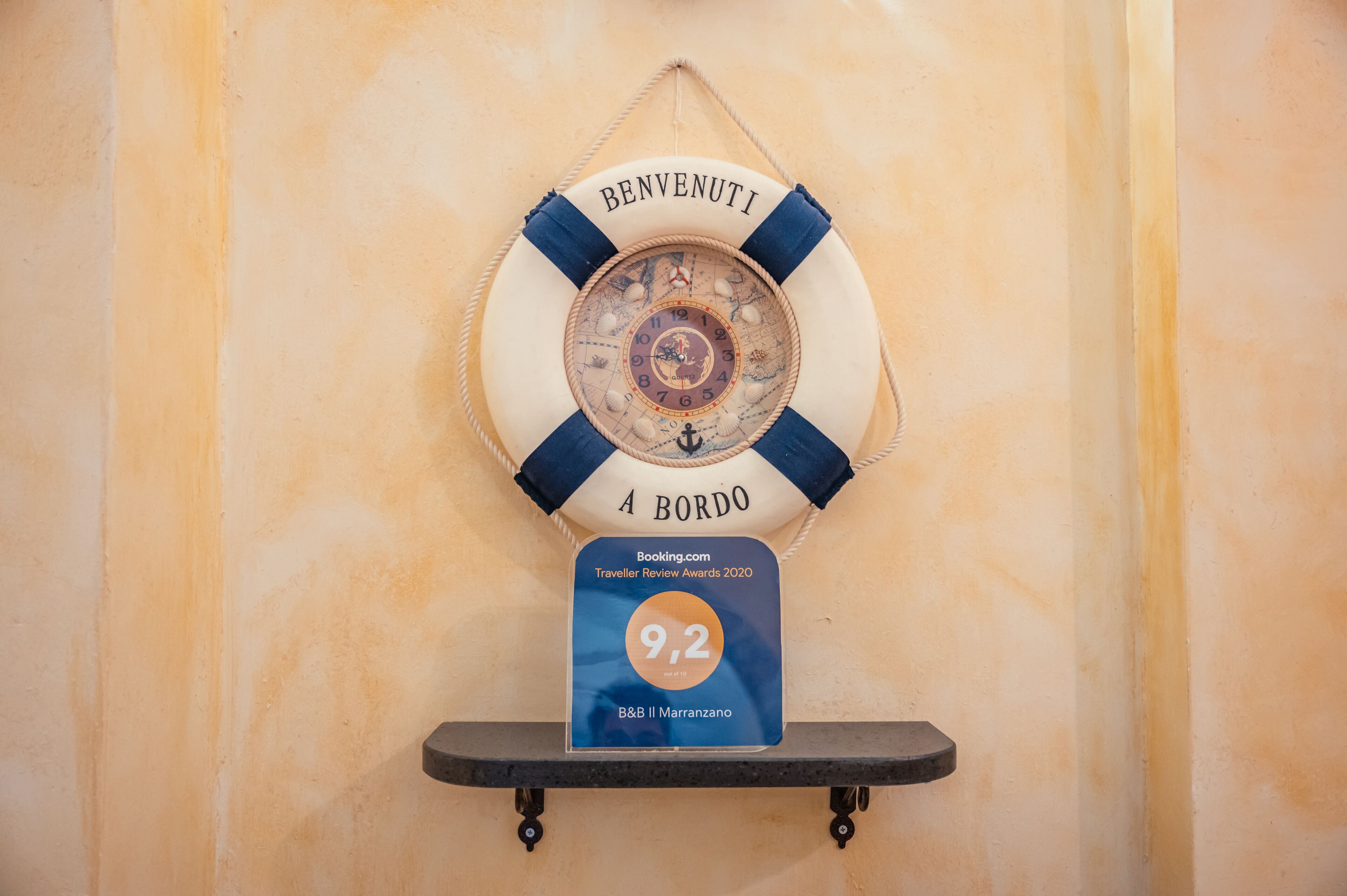 Un giubbotto di salvataggio con la scritta “BENVENUTI A BORDO” e un badge con valutazione 9.2 di Booking.com.