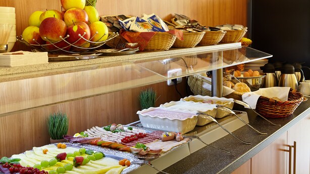A buffet with various food items including fruits, meats, and pastries. - Hotel Fresh INN (Unterhaching)