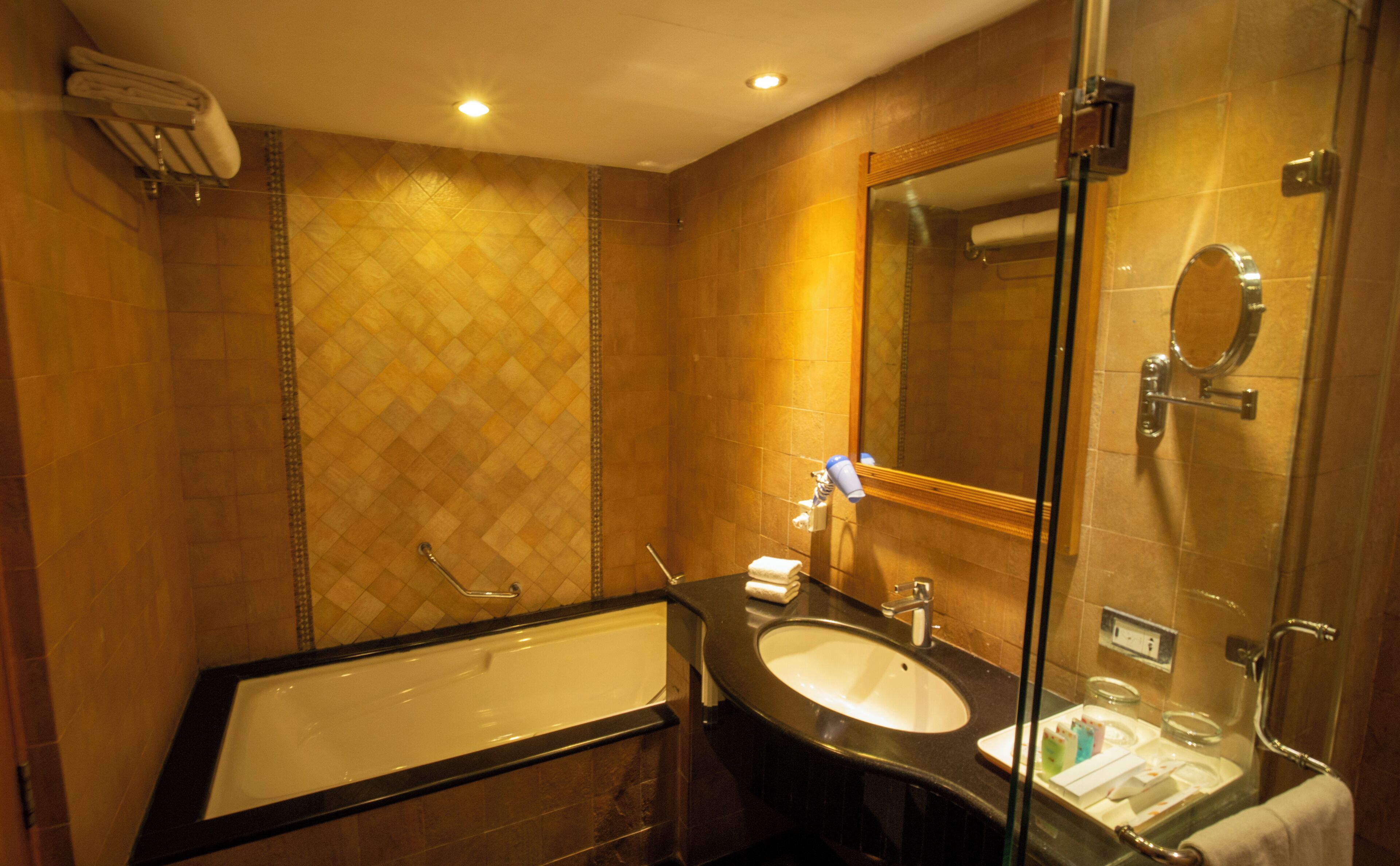 A bathroom with a bathtub, a sink, a mirror, and a shower area.