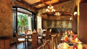 Ein Restaurant mit Holzböden, Korbmöbeln und einer Steinwand.