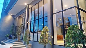 A modern building with large windows, a staircase, and potted plants. - Vismaya Suvarnabhumi Hotel (Bang Phli)