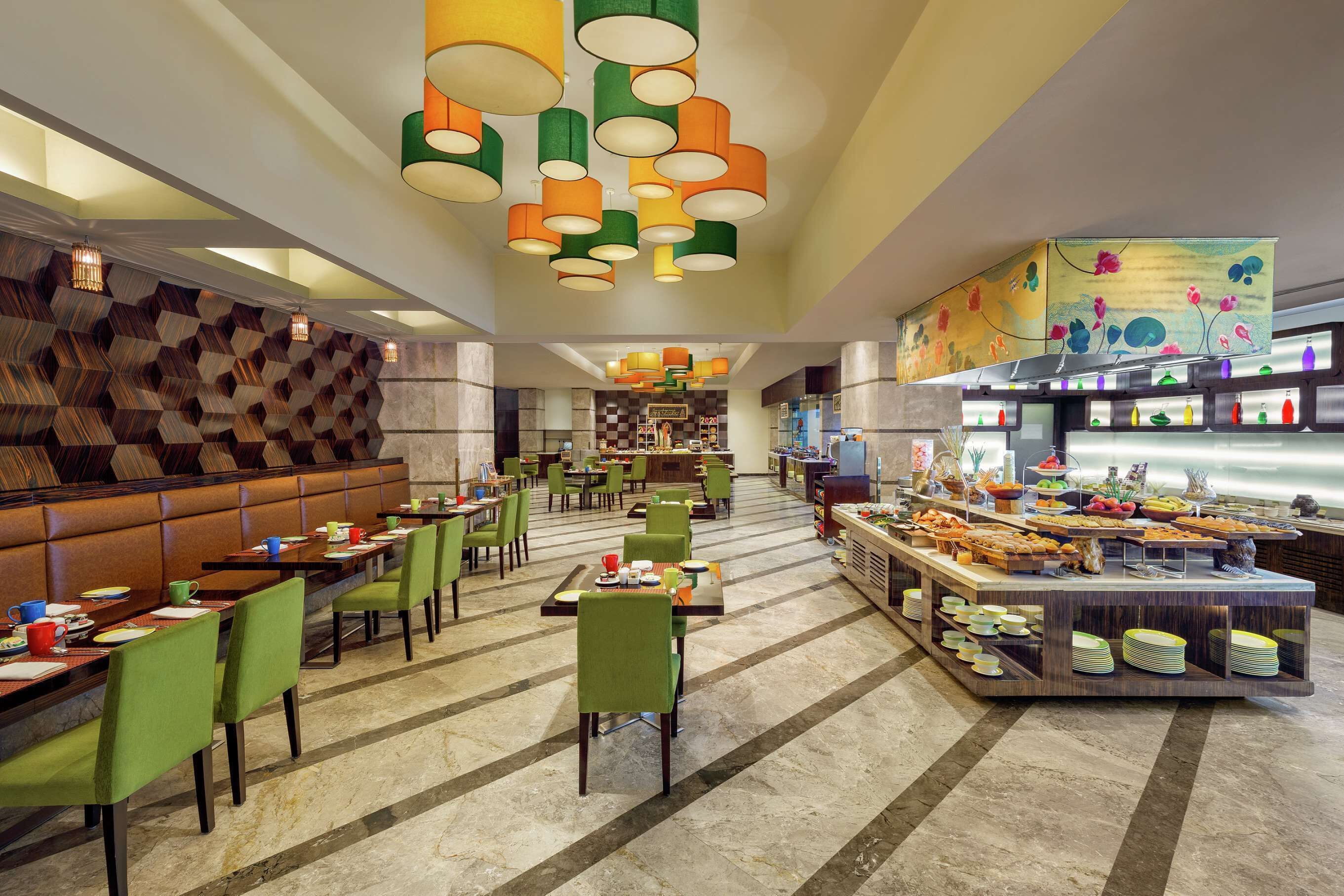 A modern dining area with multiple tables and chairs, a buffet setup, and a patterned wall.
