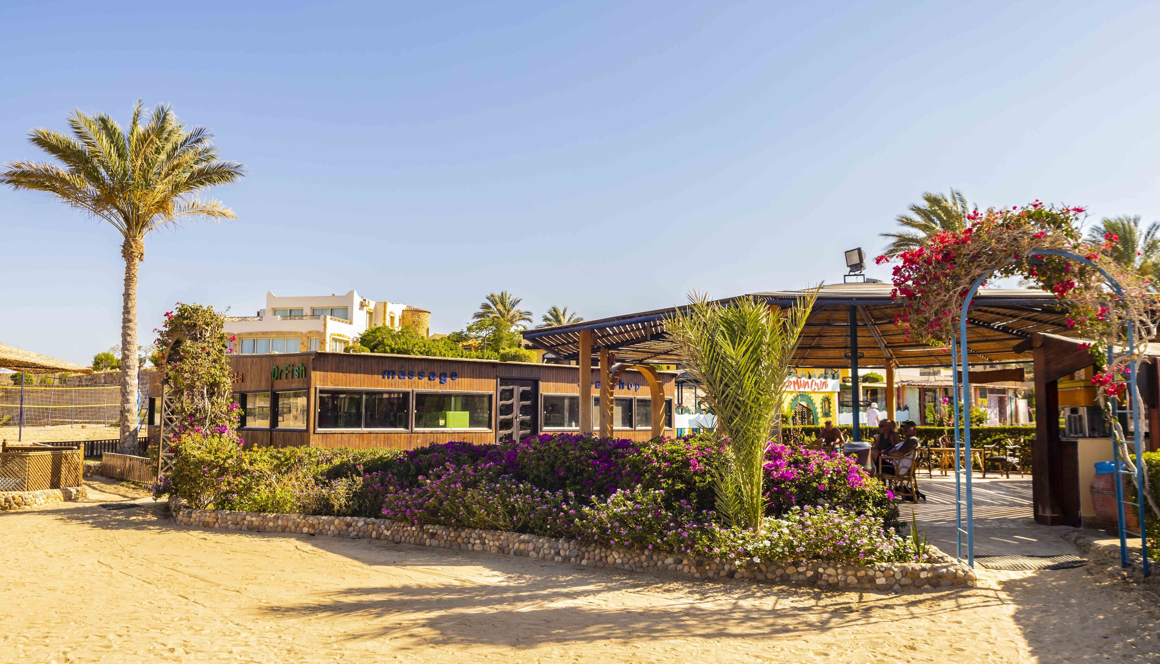 A beachside building with a wooden facade, a massage shop, and a restaurant.