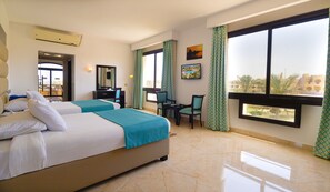 A hotel room with two beds, a desk, chairs, a large window, and a view of the city. - Blend Elphistone Resort - All inclusive (Marsa Alam)