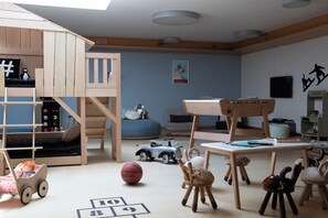A child's playroom with a loft bed, a desk, and various toys. - Schweizerhof Zermatt (Zermatt)