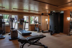 A gym with various exercise equipment, including treadmills, stationary bikes, and weight machines. - Schweizerhof Zermatt (Zermatt)