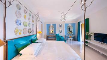 A modern hotel room with a large bed, a TV, a desk, and a chair.