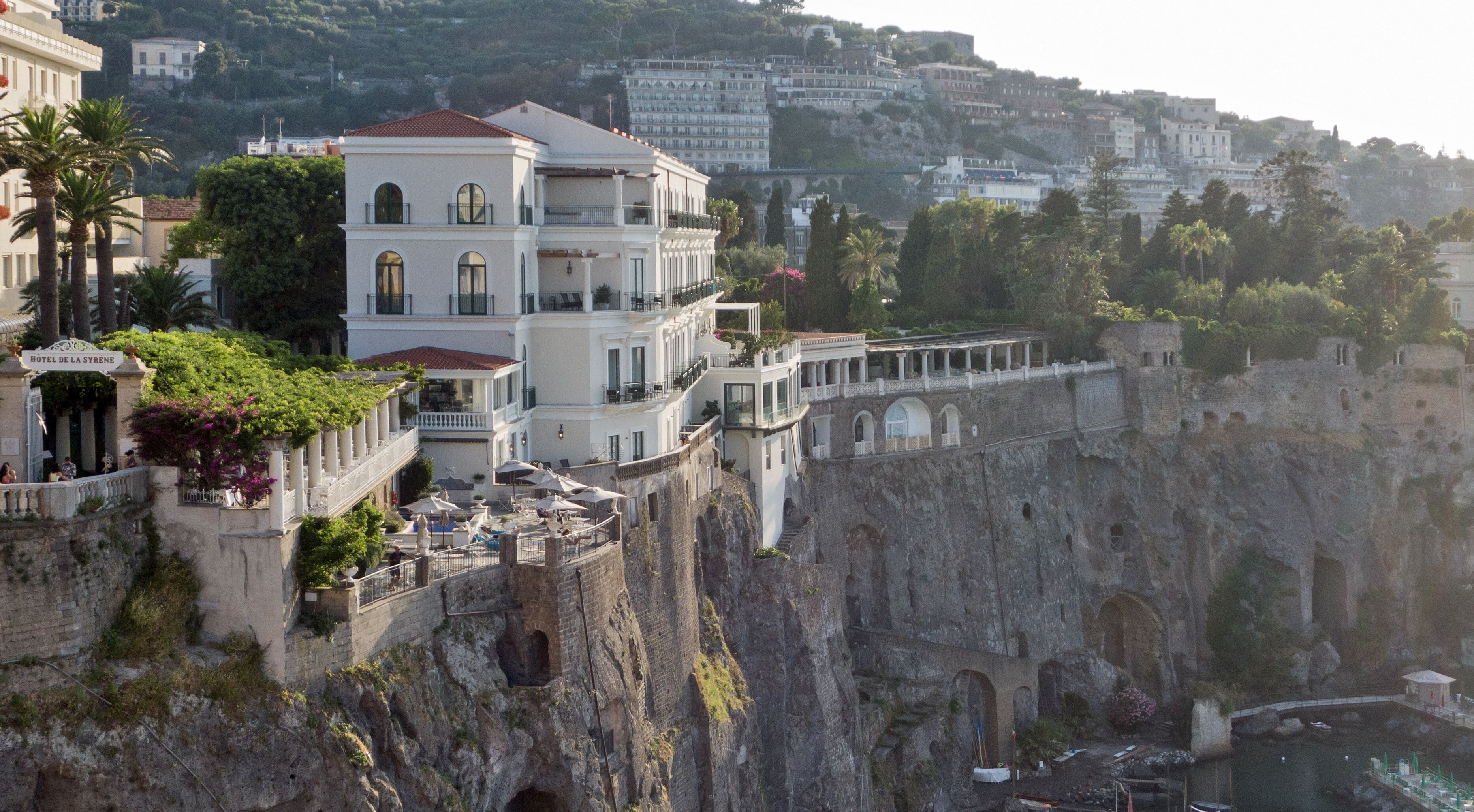 Un hôtel perché au sommet d’une falaise, offrant une vue sur la ville en contrebas.