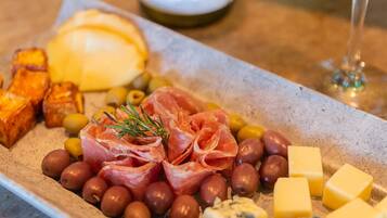 A charcuterie board with various meats, cheeses, and olives.