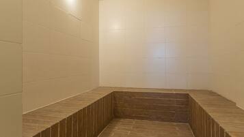A bathroom with tiled walls and a wooden floor.