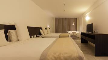 A hotel room with two beds, a desk, a chair, a television, and a curtain wall.