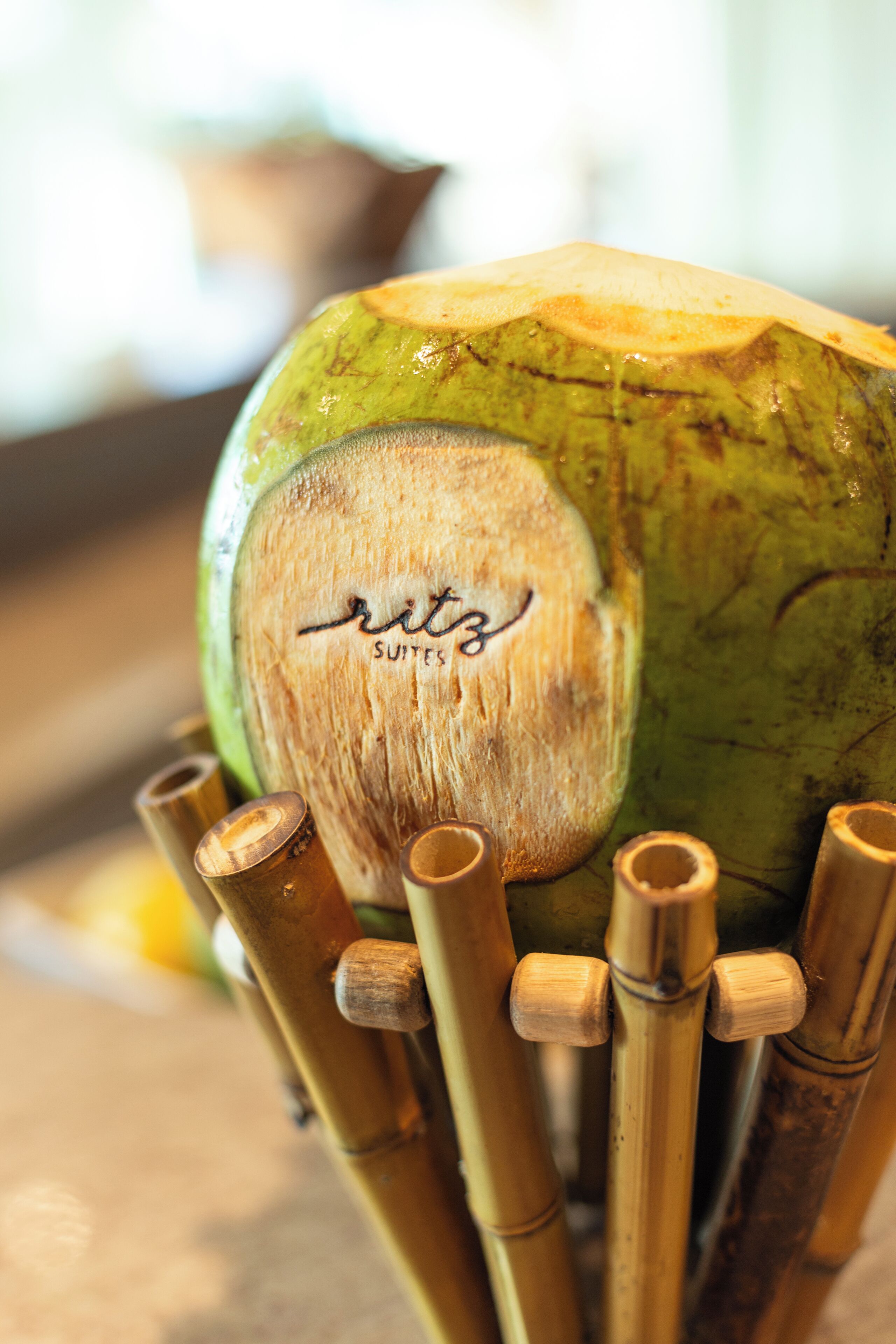 Primer plano de un coco verde con un mango de madera y el texto 