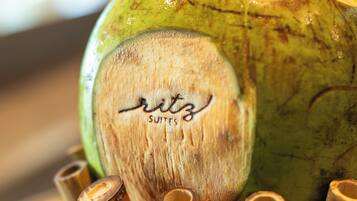 Primer plano de un coco verde con un mango de madera y el texto