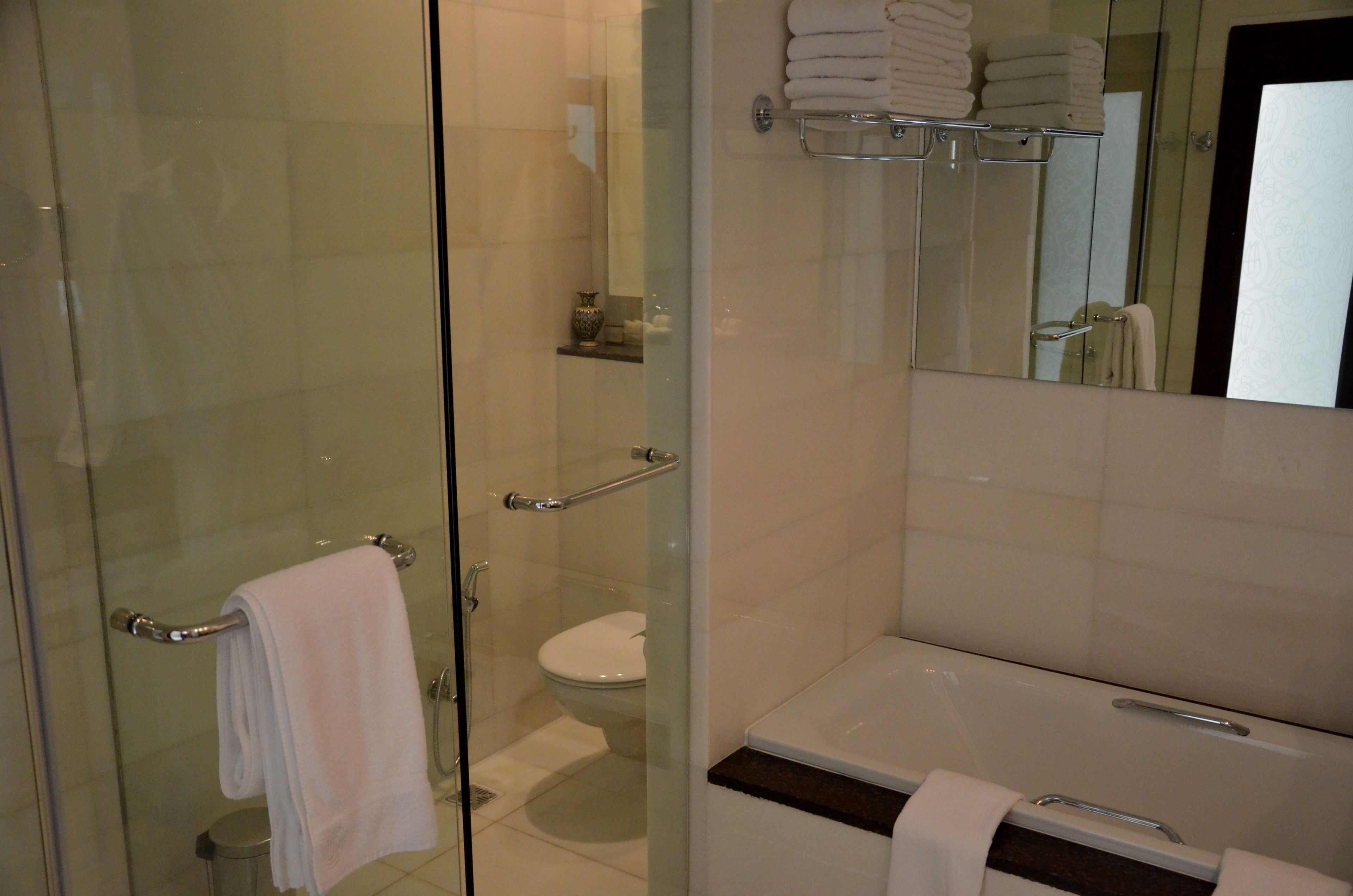 Une salle de bain moderne avec une douche à parois de verre, des toilettes et un lavabo équipé d’un porte-serviettes.