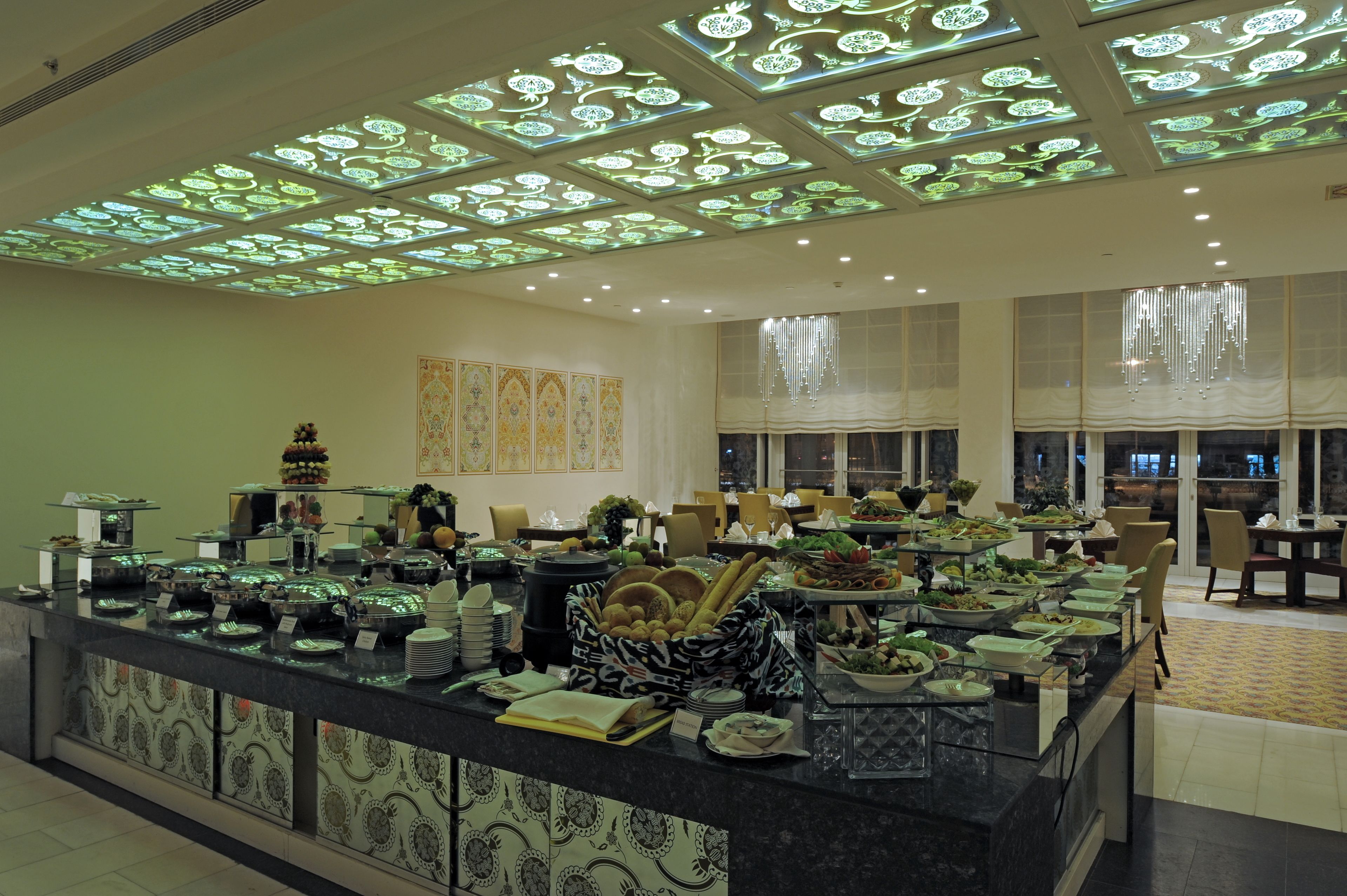 A buffet setup with various food items and a decorative ceiling.