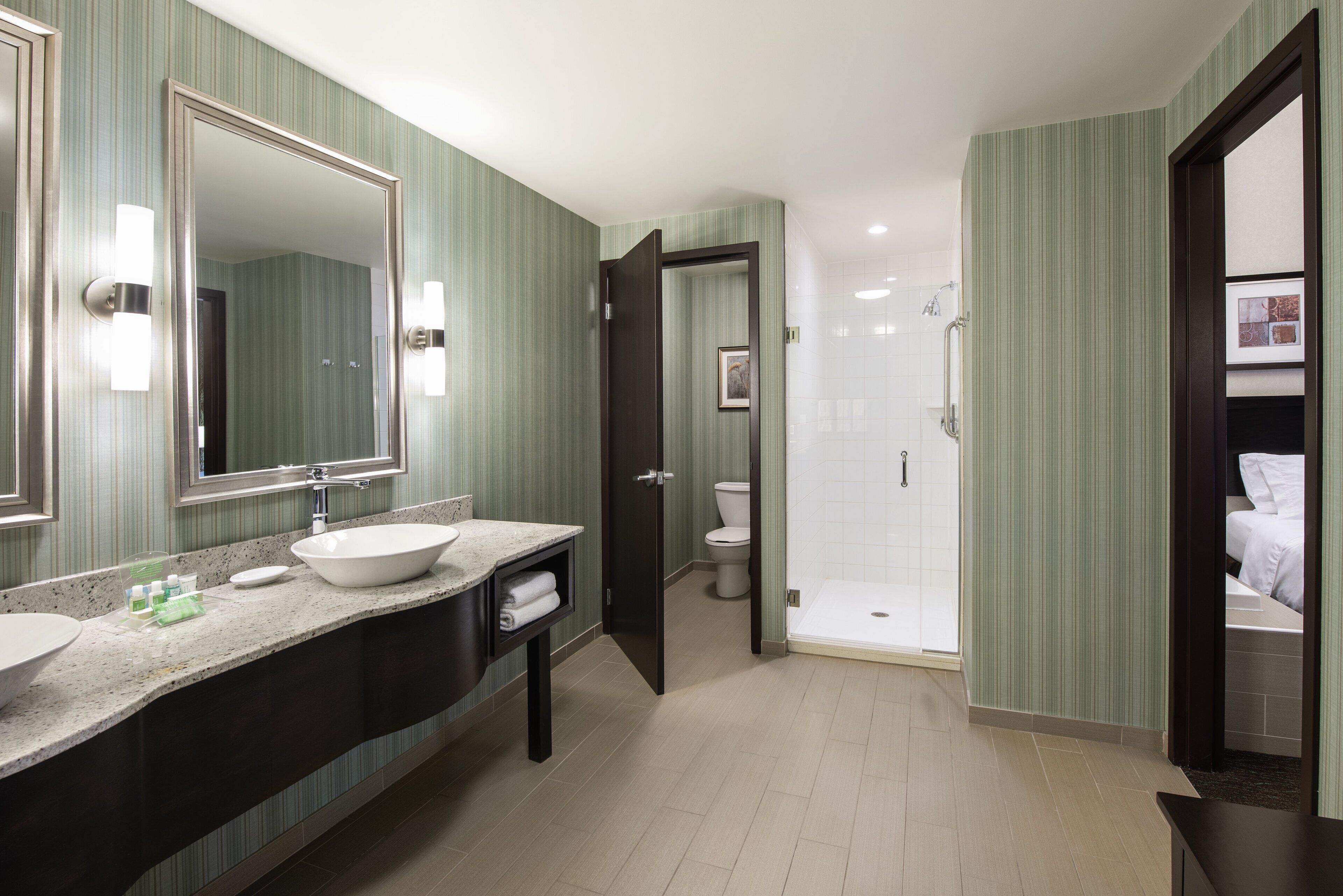Un baño moderno con un lavamanos grande, un espejo y una zona de ducha.