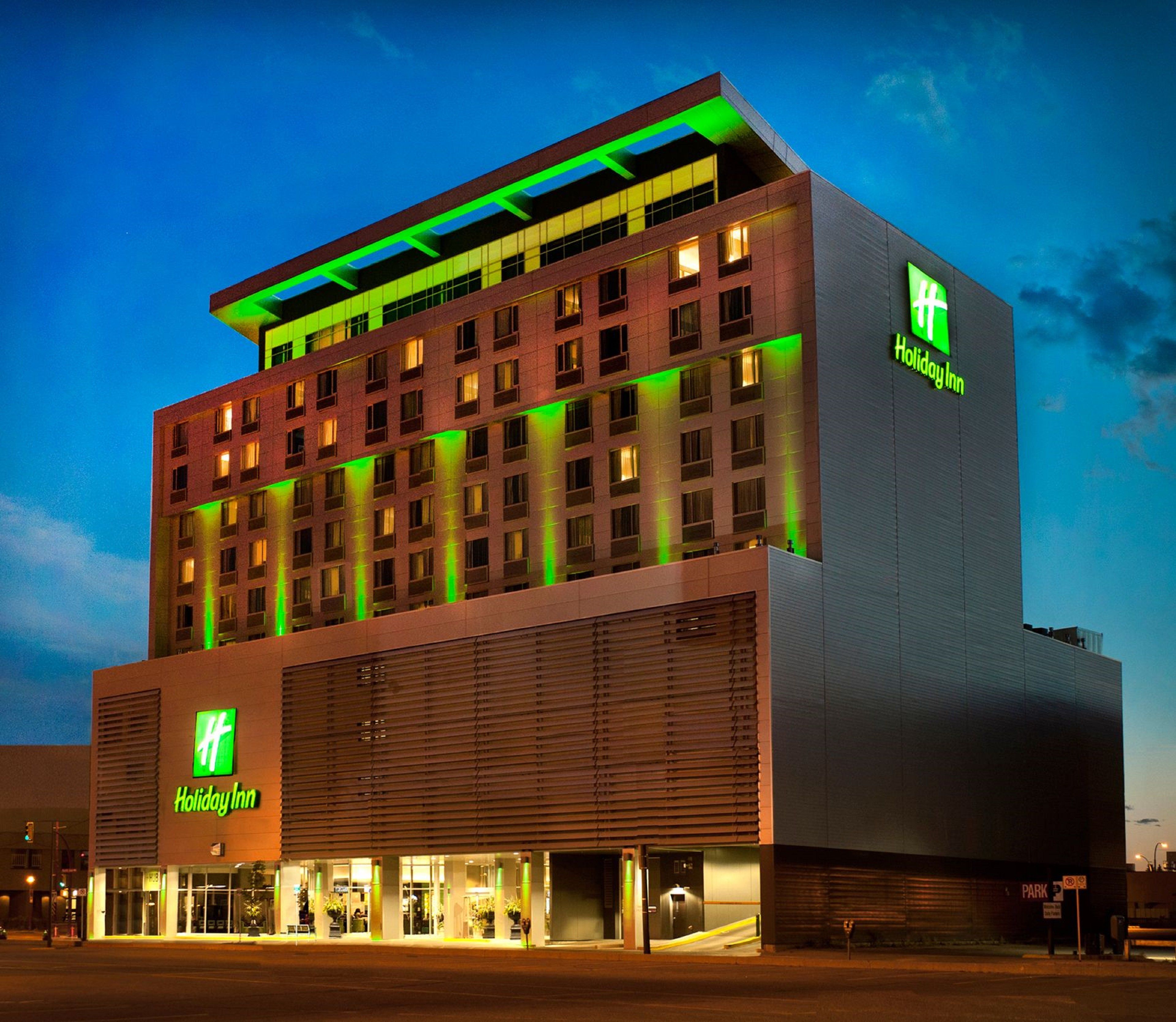 Un hôtel Holiday Inn au design moderne, caractérisé par un toit plat et de grandes fenêtres.