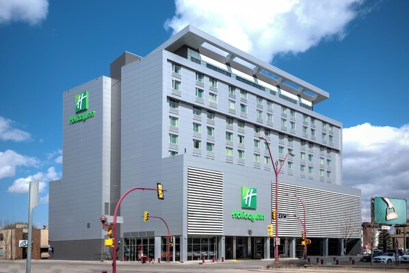A modern Holiday Inn hotel with a prominent 'Holiday Inn' sign on the facade, large windows, and a flat roof design. - Holiday Inn Hotel & Suites Saskatoon Downtown by IHG (Saskatoon)