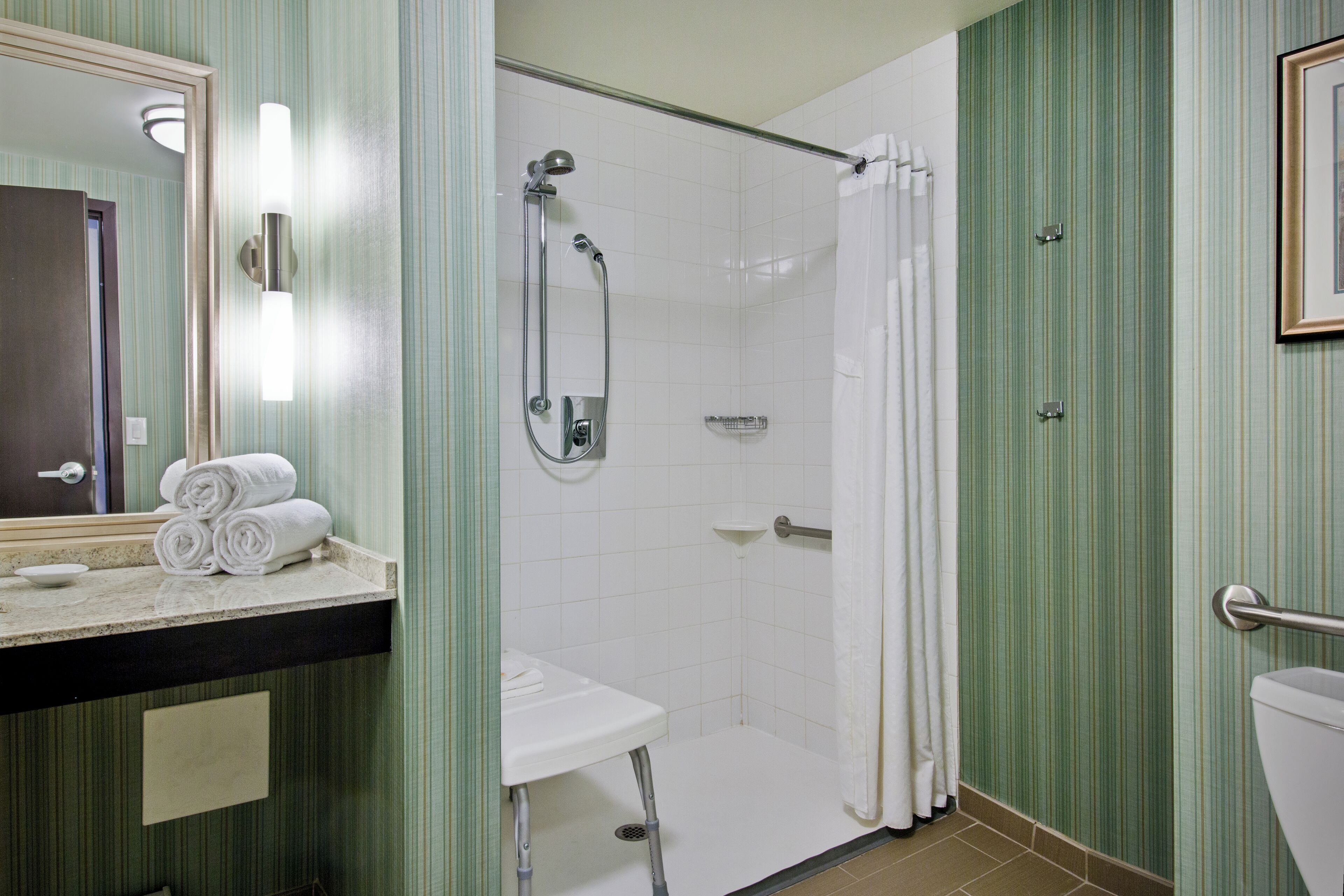 Une salle de bain avec douche, toilettes et lavabo.