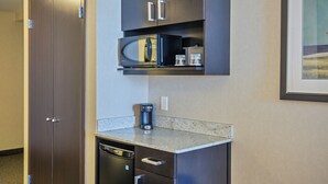 A compact kitchenette with a microwave, coffee maker, and a dishwasher. - Holiday Inn Hotel & Suites Saskatoon Downtown by IHG (Saskatoon)
