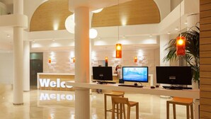 A modern reception area with a 'Welcome' sign, two computer monitors, and a reception desk.