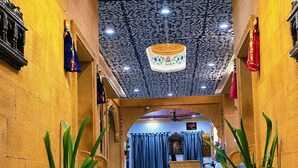 A grand entrance with a marble staircase, ornate ceiling, and potted plants. - Hotel Moonlight (Jaisalmer)