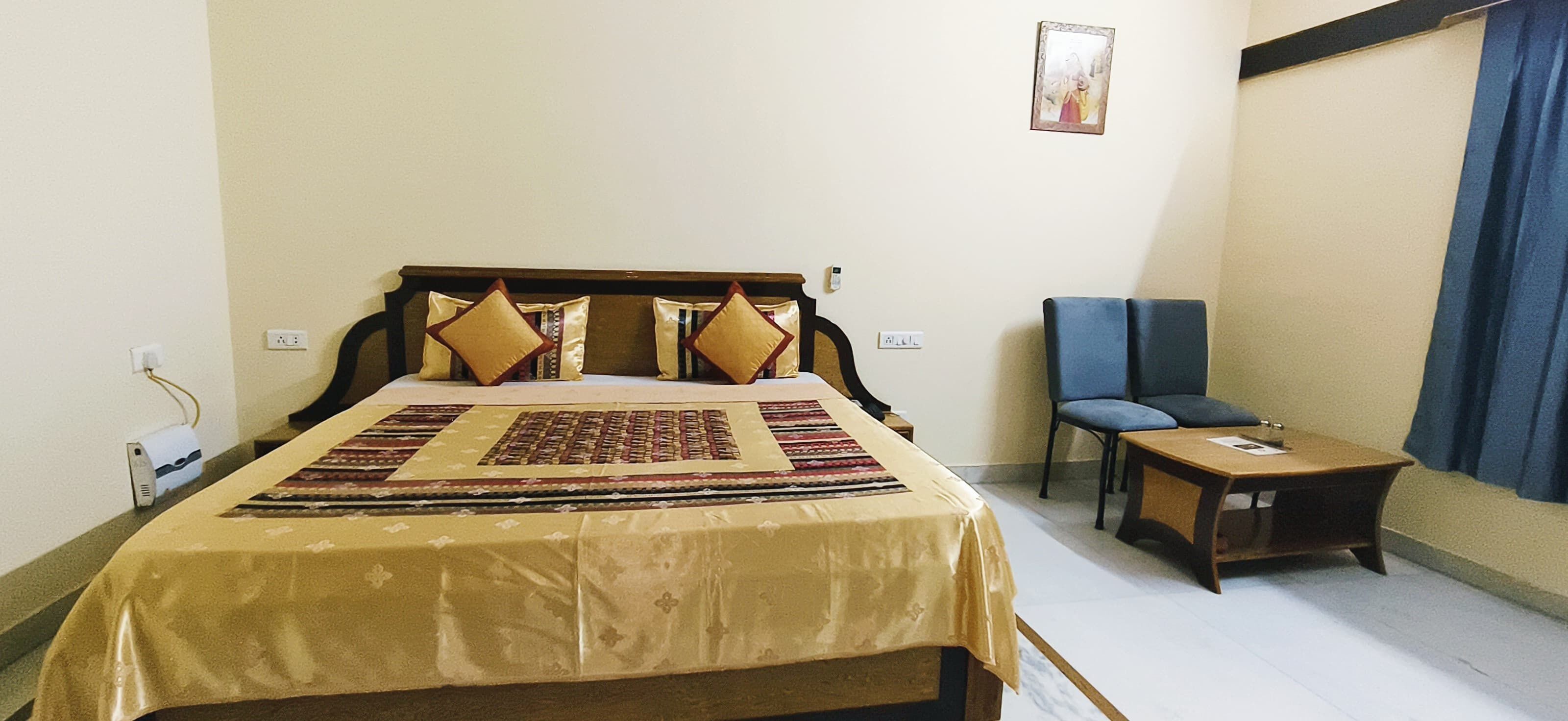 Un dormitorio ordenado con cama, una silla y una mesita.