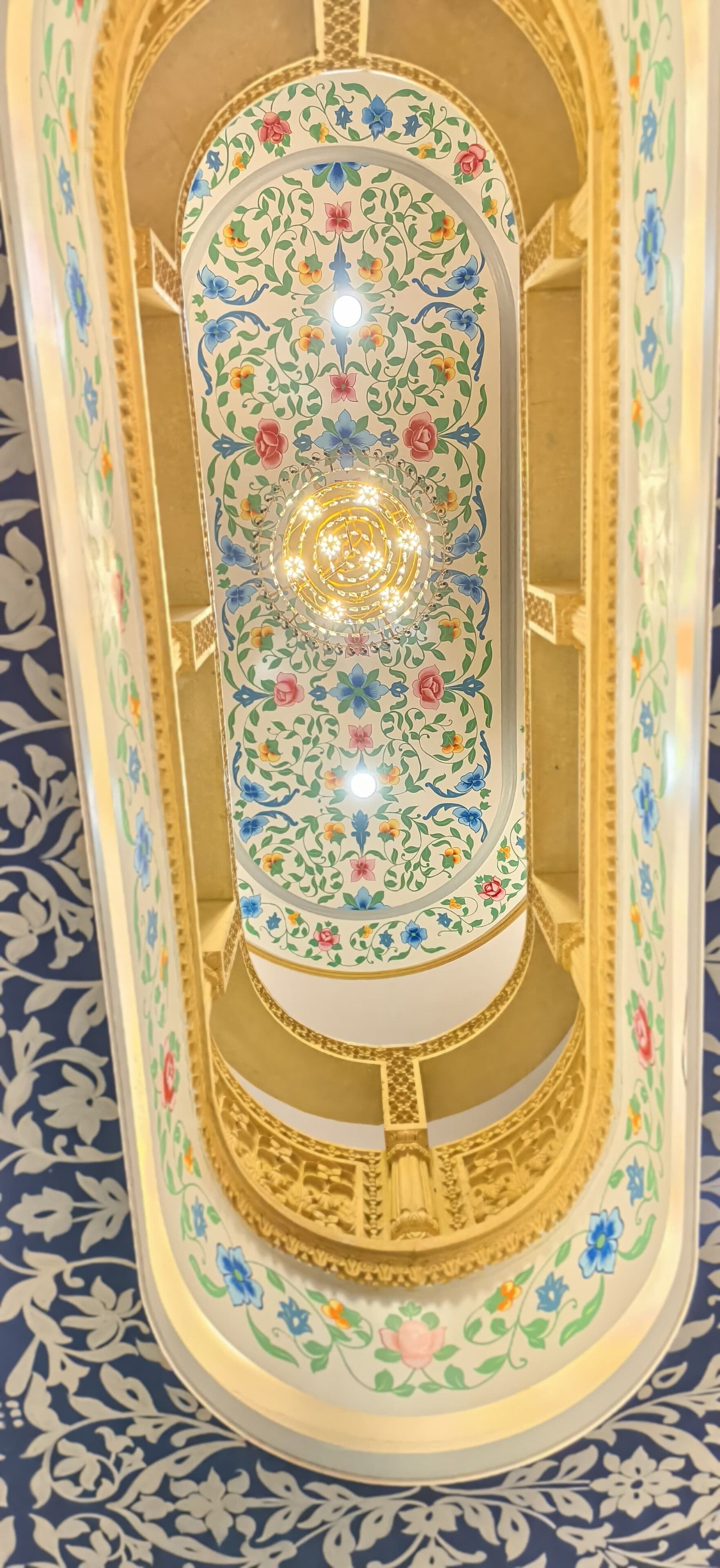 Un objeto decorativo, ornamentado y con un diseño intrincado, con motivos florales y una lámpara circular central.