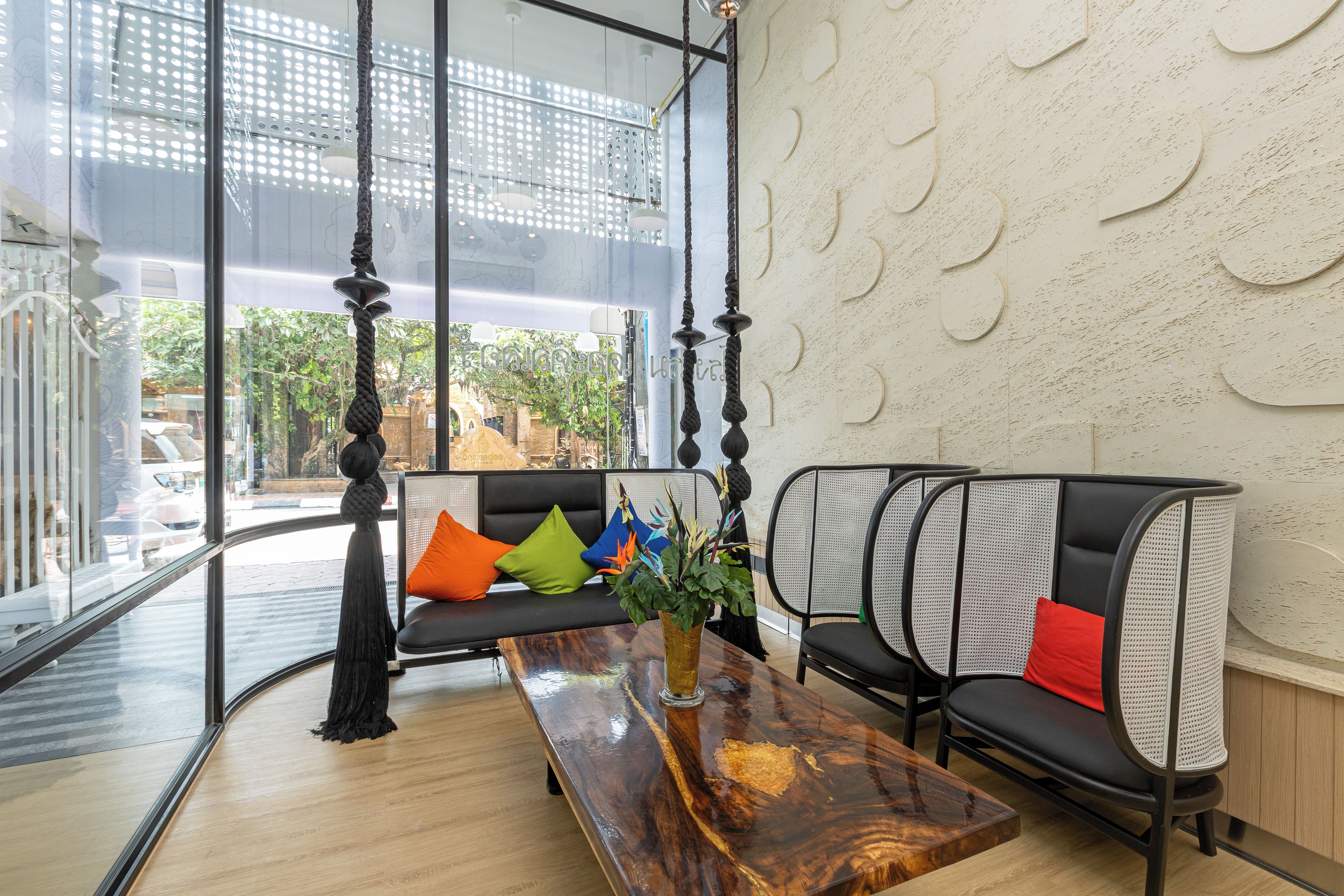 A modern interior with a wooden coffee table, black and white upholstered seating, and a glass partition.