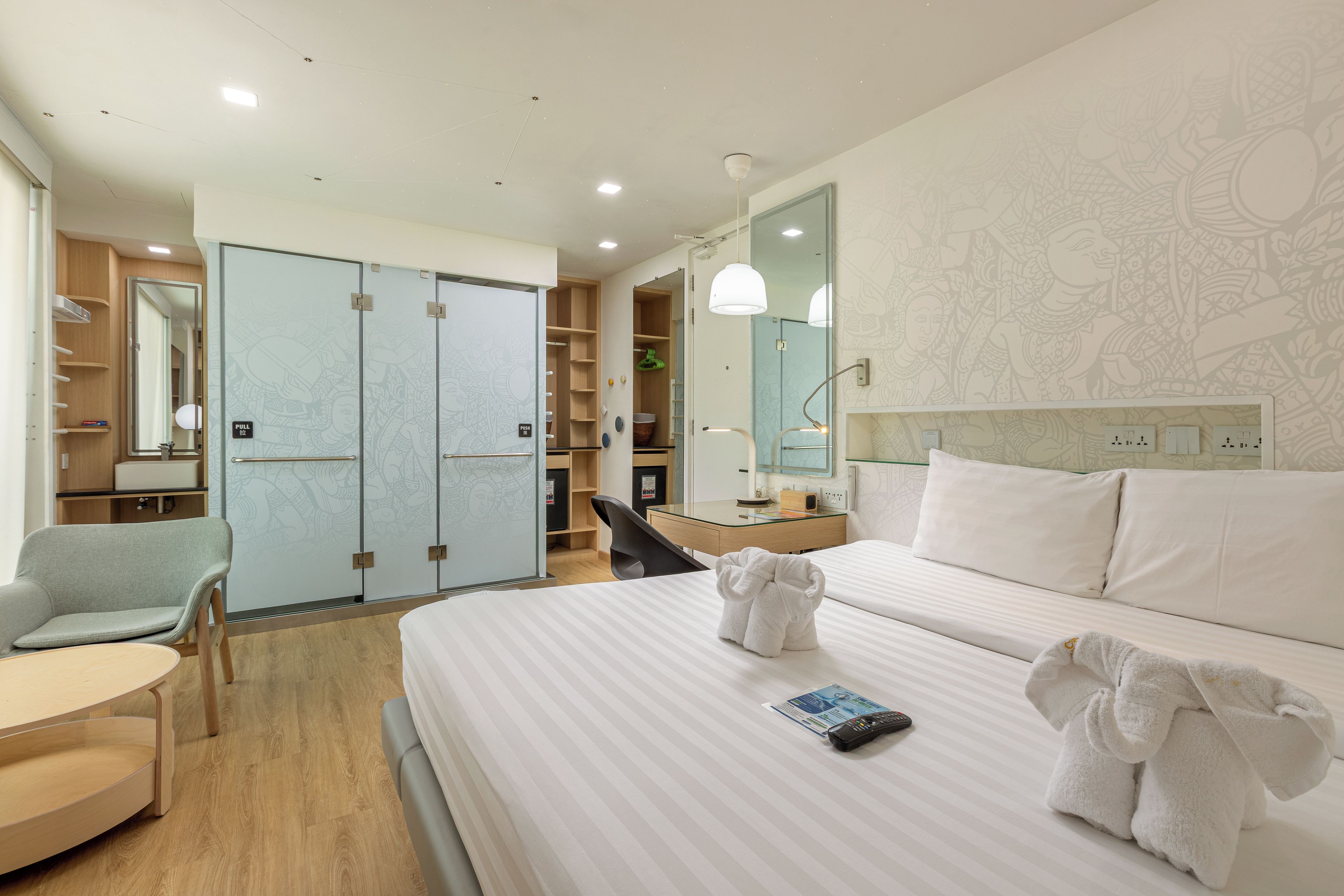 Ein Hotelzimmer mit einem Bett, einem Sessel, einem Schreibtisch und einem Kleiderschrank.