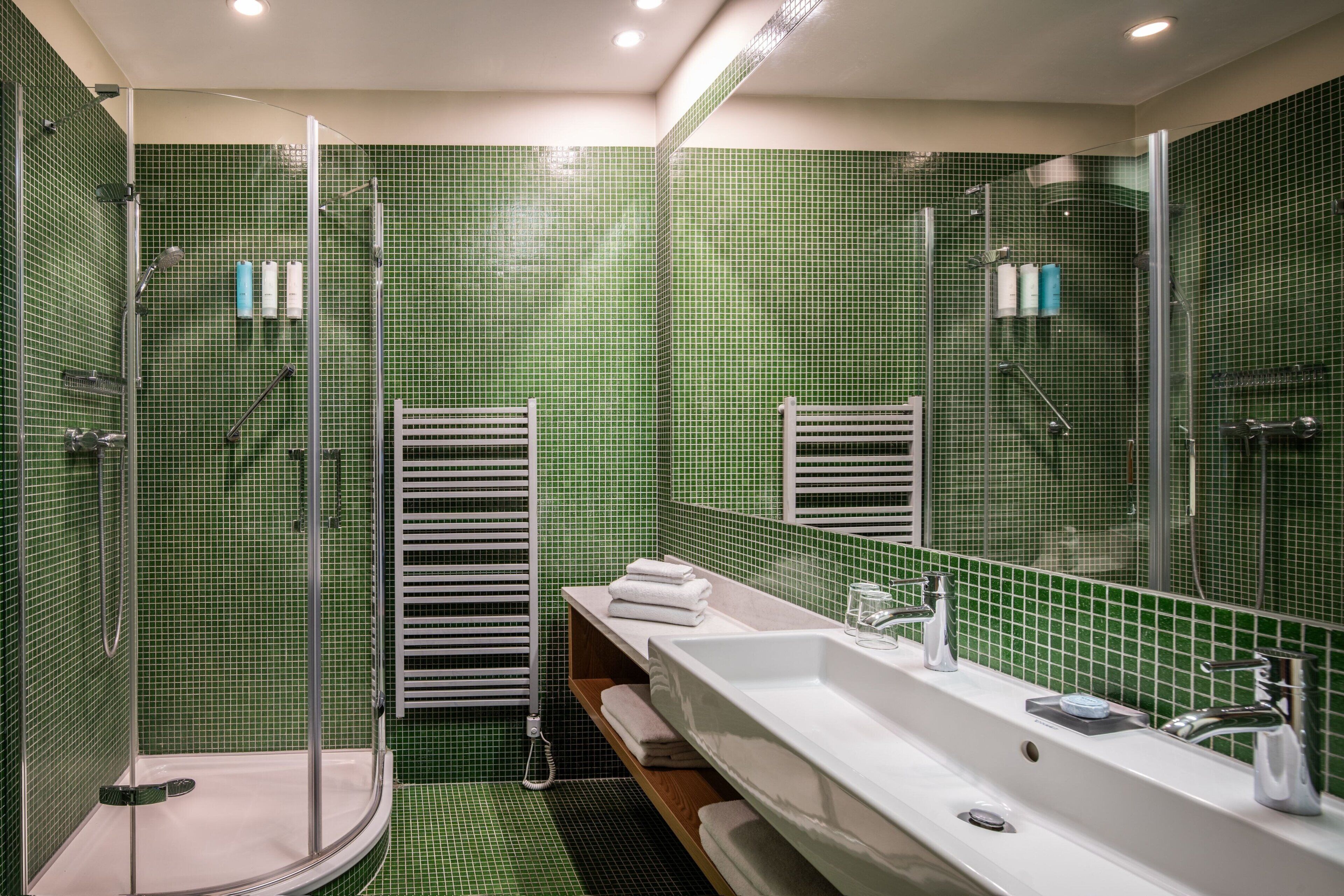 A bathroom with a shower, a sink, and a mirror.
