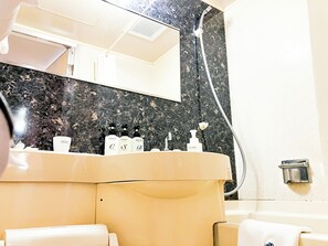 A bathroom with a marble countertop, a sink, and a mirror. There are toiletries on the counter, including a bottle of lotion, a shampoo bottle, and a body wash. - Hotel Livemax Naha (Naha)