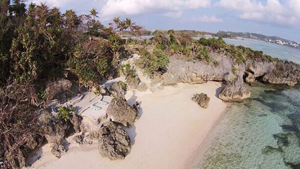 A beach with clear turquoise water, rocky outcrops, and dense tropical vegetation. - Lingganay Boracay Hotel Resort (Boracay Island)