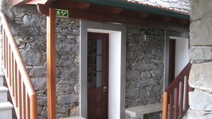 A stone building with a wooden staircase and a door. - Casa D'Avó Beatriz (Santa Cruz)