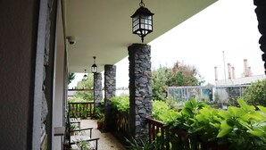 A covered outdoor area with stone pillars, hanging lanterns, and potted plants. - Casa D'Avó Beatriz (Santa Cruz)