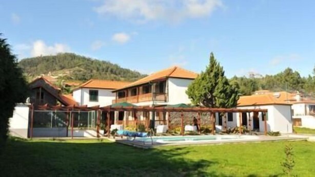 A two-story house with a swimming pool, surrounded by a well-maintained lawn and trees. - Casa D'Avó Beatriz (Santa Cruz)