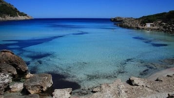 Una spiaggia nelle vicinanze, sabbia bianca, lettini da mare, ombrelloni