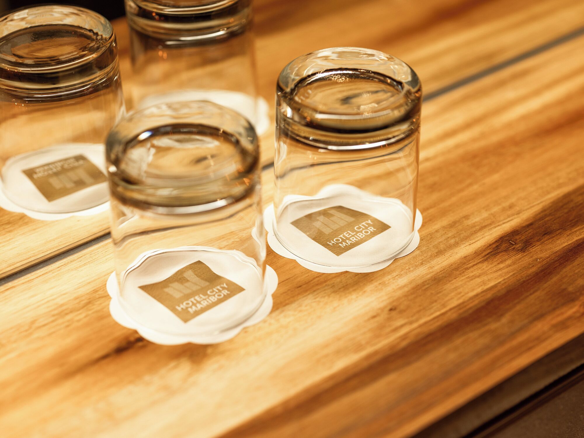 Four glass bottles with labels on a wooden surface.