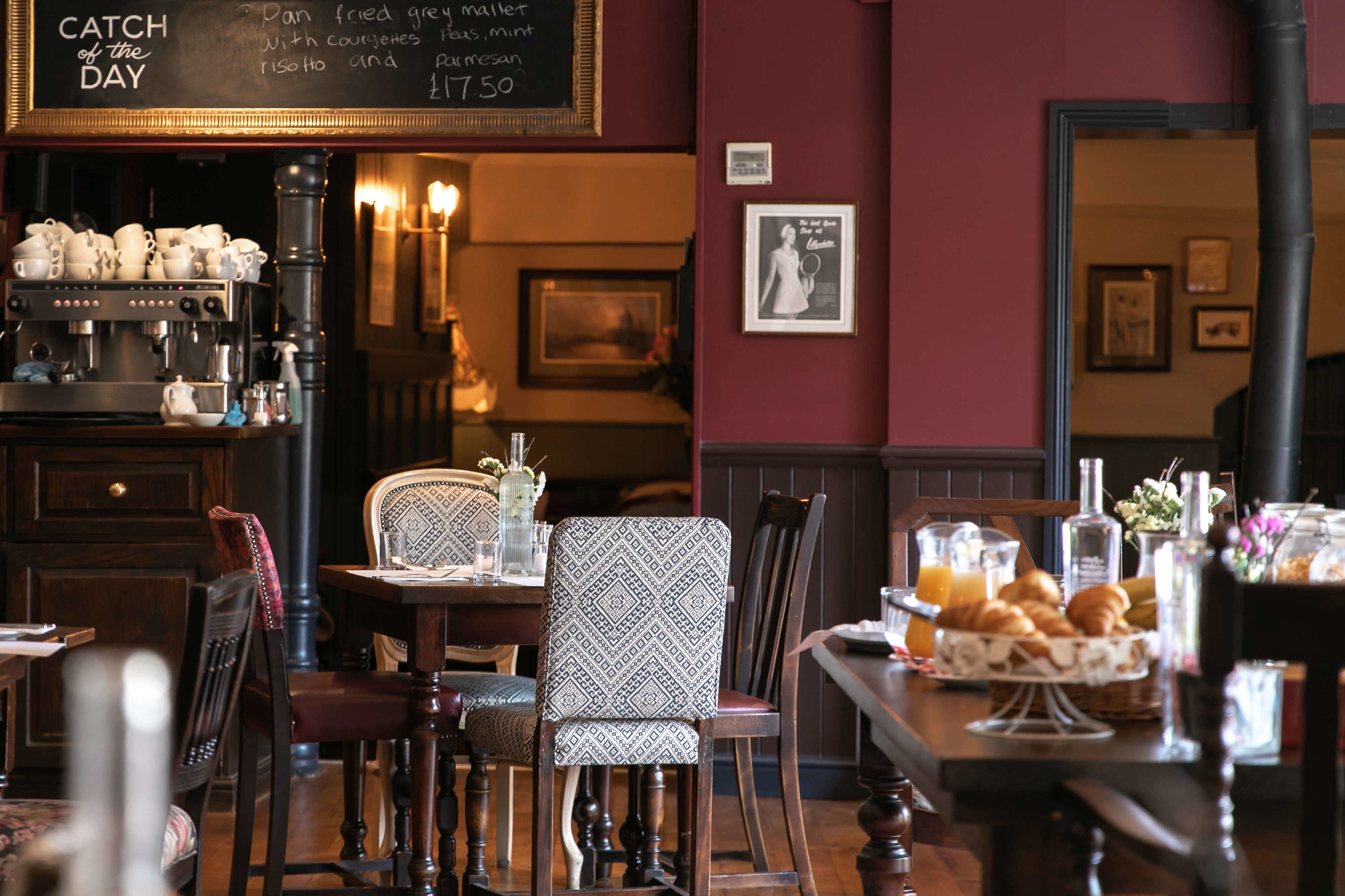 Un café acogedor con un menú en la pizarra, muebles de madera y una variedad de desayuno.