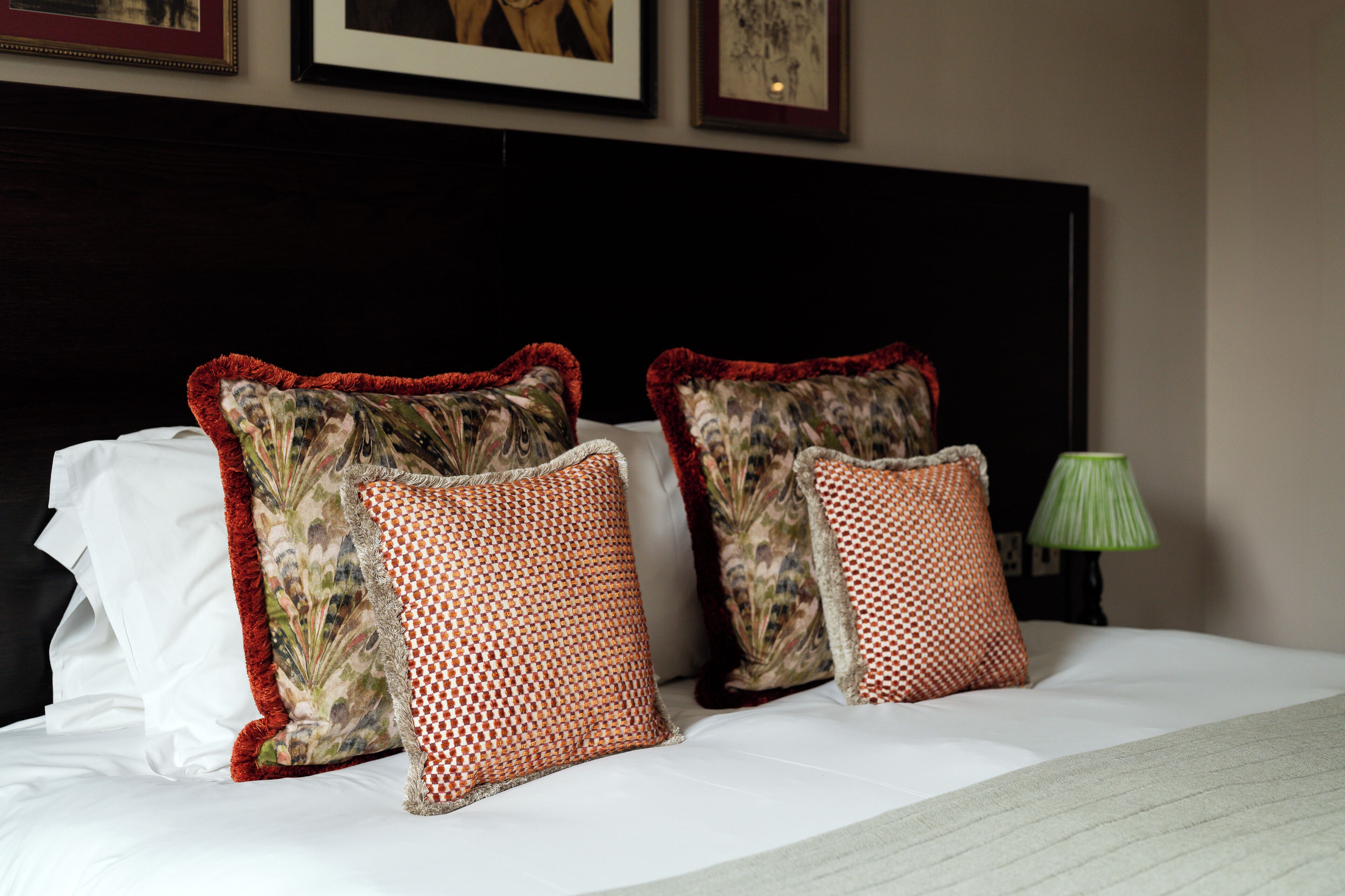 A neatly made bed with white linens and decorative pillows.