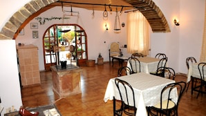 Un restaurante con arcos de ladrillo, mesas de madera y lámparas colgantes.