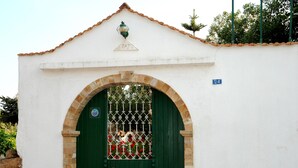 Un edificio blanco con puerta verde y un pequeño balcón.